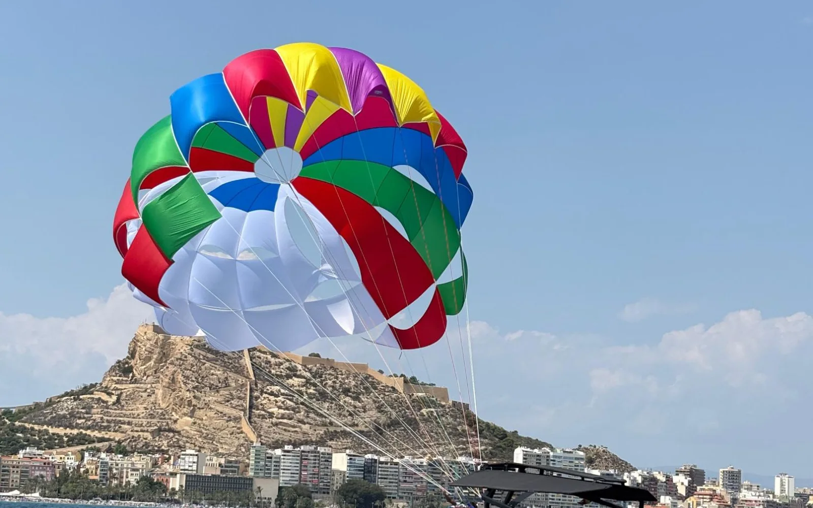 Barco de Love Parasailing frente al castillo de Santa Bárbara